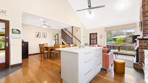 Enjoy meals in the kitchen with a central island and dining area, featuring a staircase to the upper level and a brick fireplace.