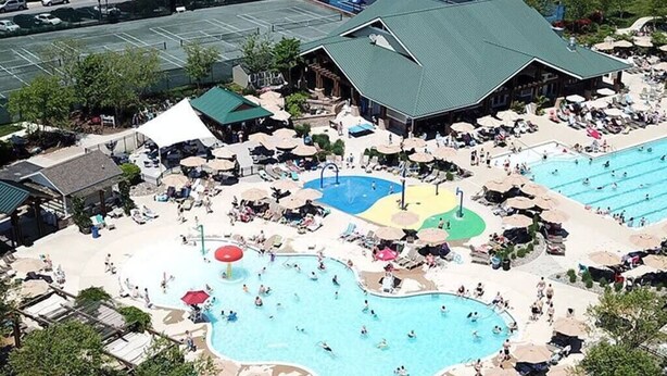 Vue aérienne d’un complexe hôtelier doté de plusieurs piscines, de chaises longues et de parasols.