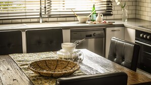 A kitchen with a dining table set for four, a sink, and a stove. - Prime location Sunny 3bedroom apartment (Tel Aviv)