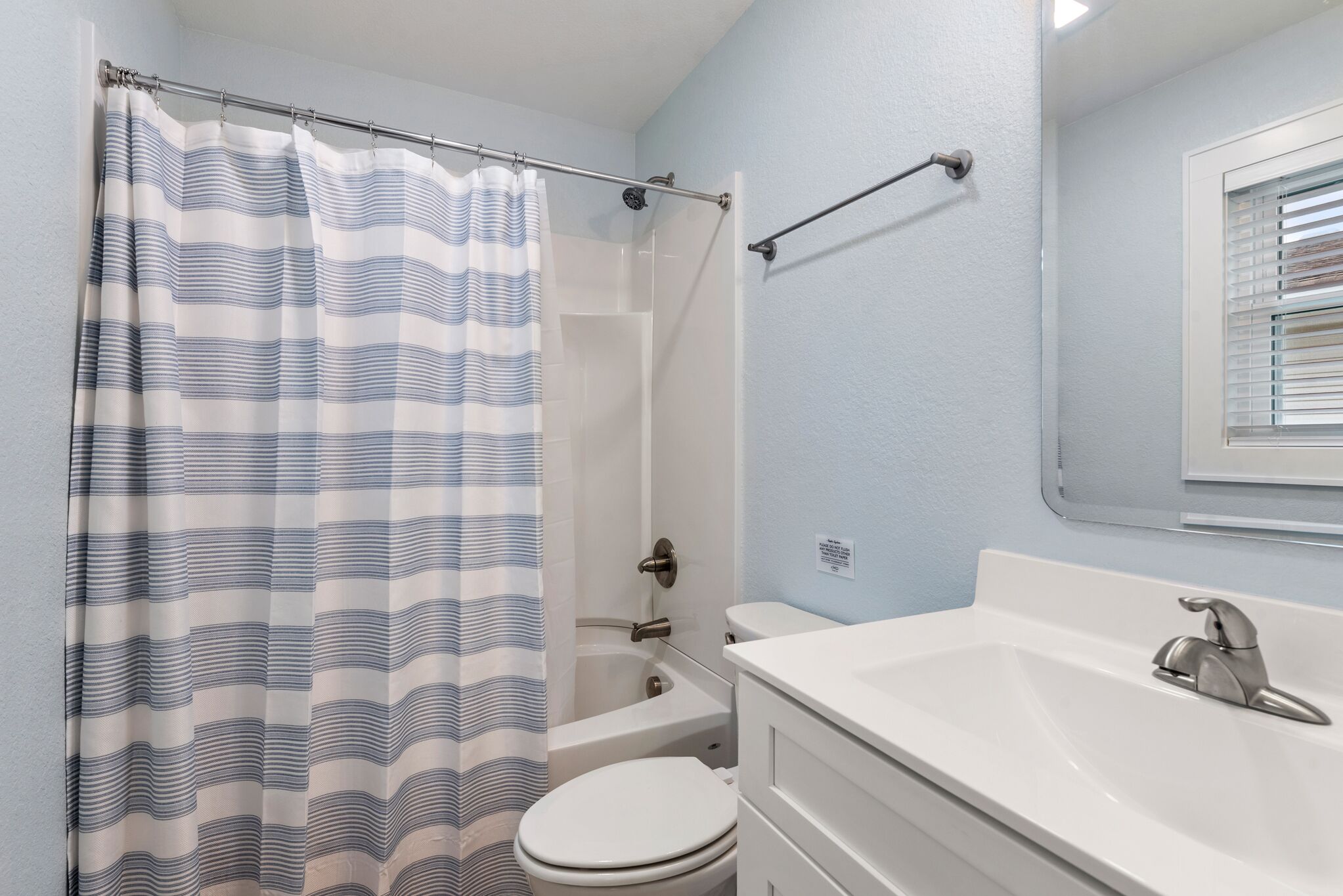 A bathroom with a shower, toilet, and sink.