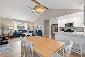 A modern kitchen with white cabinets, a stainless steel refrigerator, and a microwave. - Wright On Time: Central Location | Dogs Welcome (Kill Devil Hills)