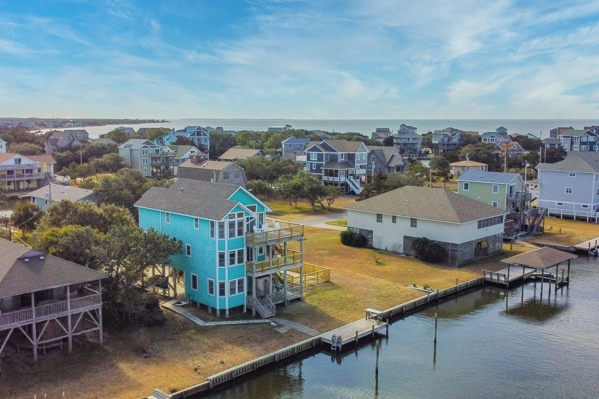 A coastal residential area with houses, a dock, and a water body.