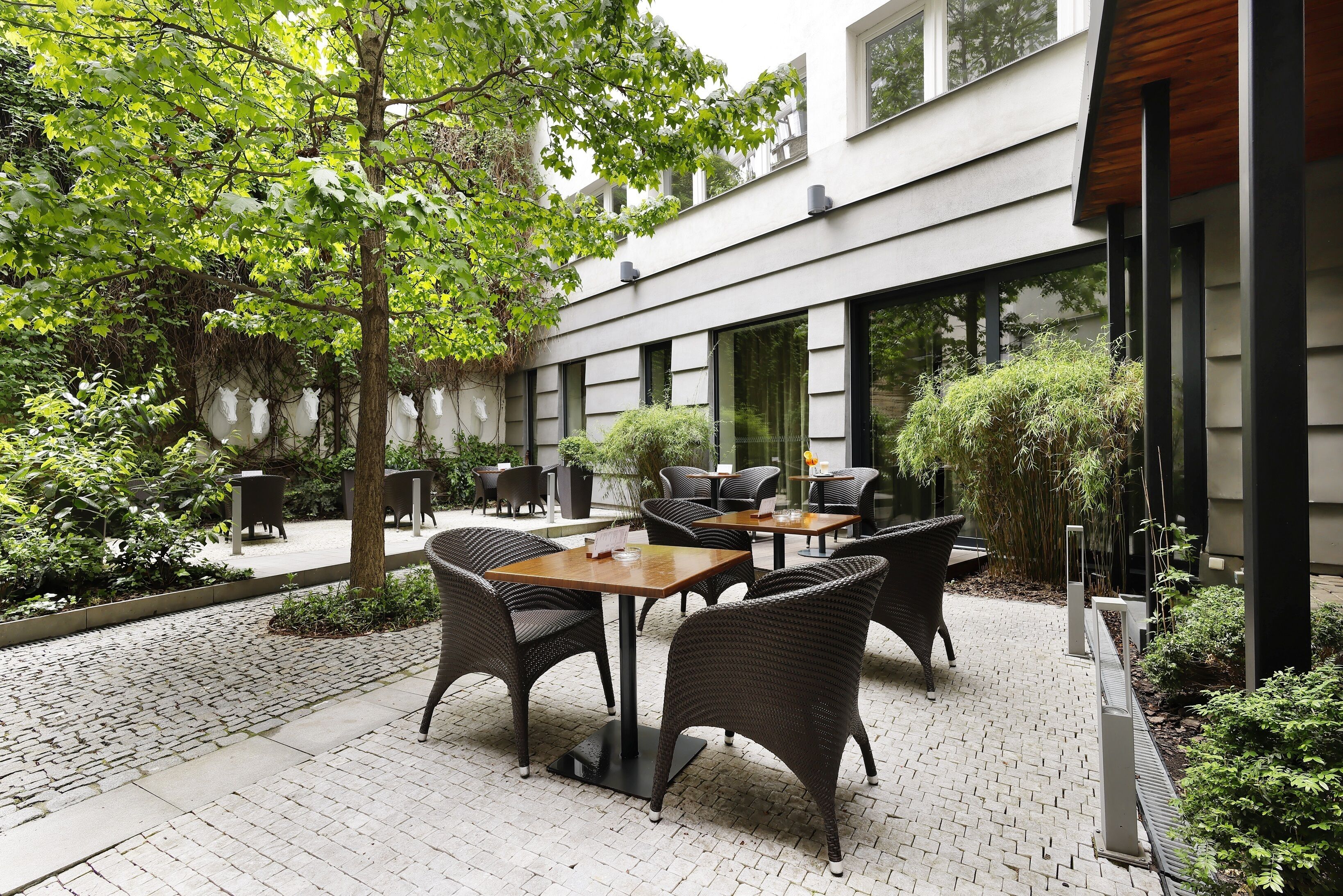 Eine Terrasse im Freien mit Korbmöbeln und einem Ziegelweg.