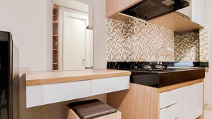 Una cocina moderna con encimera de madera, estufa negra y salpicadero de azulejos.