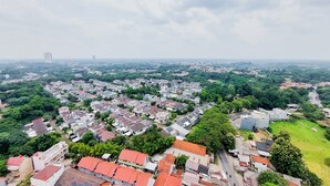 Vista aérea de una zona residencial con varios edificios, calles y zonas verdes.