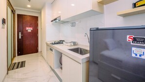A modern kitchen with a built-in gas stove, a stainless steel sink, and a refrigerator with a compressor warranty sticker.