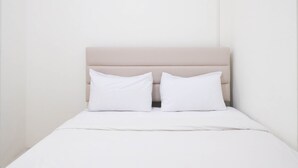A single bed with a beige headboard and two white pillows. - Spacious And Best Deal 2Br Apartment At Puncak Bukit Golf Surabaya (Surabaya)