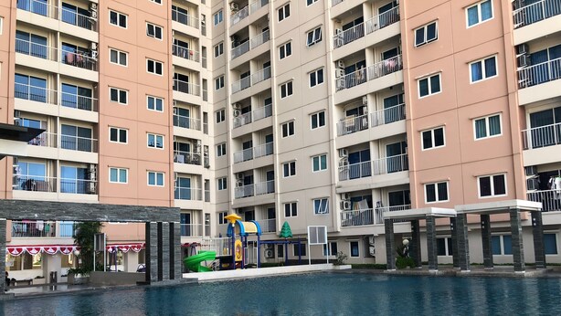A residential building with multiple balconies, a swimming pool, and a children's play area. - Spacious And Best Deal 2Br Apartment At Puncak Bukit Golf Surabaya (Surabaya)