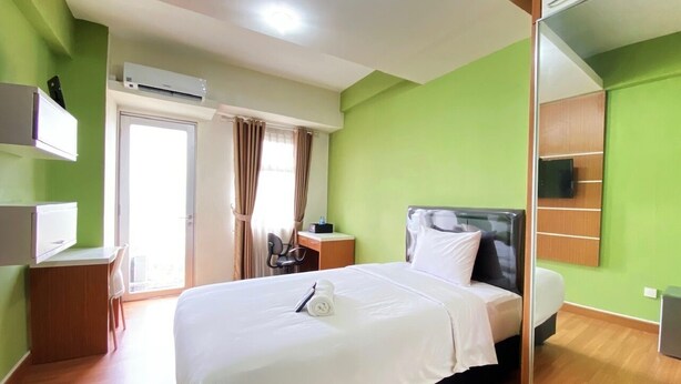 Une chambre d’hôtel équipée d’un lit, d’un bureau, d’une chaise, d’une télévision et d’un miroir.