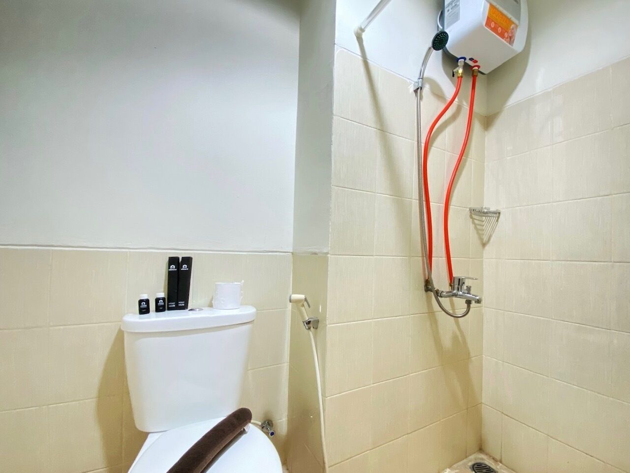 Une salle de bain équipée de toilettes, d’une douche et d’un chauffe-eau.