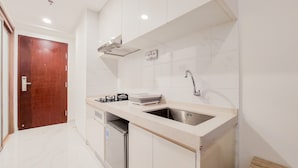A modern kitchen with white cabinets, a stainless steel sink, and a built-in dishwasher. - Great Deal And Comfortable Studio At Sky House Bsd Apartment (Pagedangan)