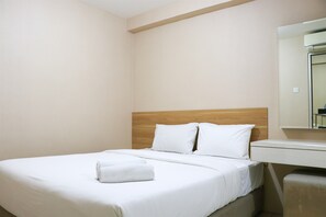 Cama bem arrumada com lençóis brancos e uma toalha enrolada, uma cabeceira de madeira e uma pequena mesa de cabeceira com espelho.