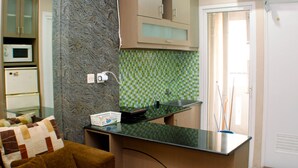 A compact kitchen with a microwave, a sink, and a countertop. - Nice And Best Deal 2Br At Green Pramuka City Apartment (Jakarta)