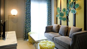 A modern living room with a sofa, a coffee table, and a TV stand. - Nice And Relax 1Br At Grand Sungkono Lagoon Apartment (Surabaya)