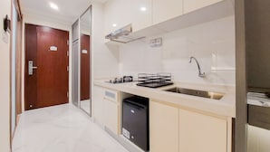 A modern kitchen with a sink, stove, and dishwasher. - Studio Room With Simply Look At Sky House Bsd Near Aeon (Pagedangan)