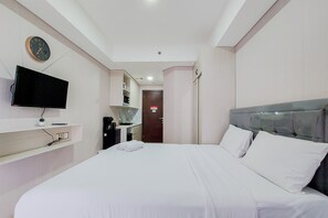 Une chambre d’hôtel avec un lit, une télévision, une horloge et une porte donnant sur une autre pièce.