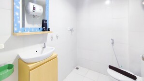 A bathroom with a white sink, mirror, and shower. - Cozy Studio At 9Th Floor Paltrow City Apartment (Semarang)