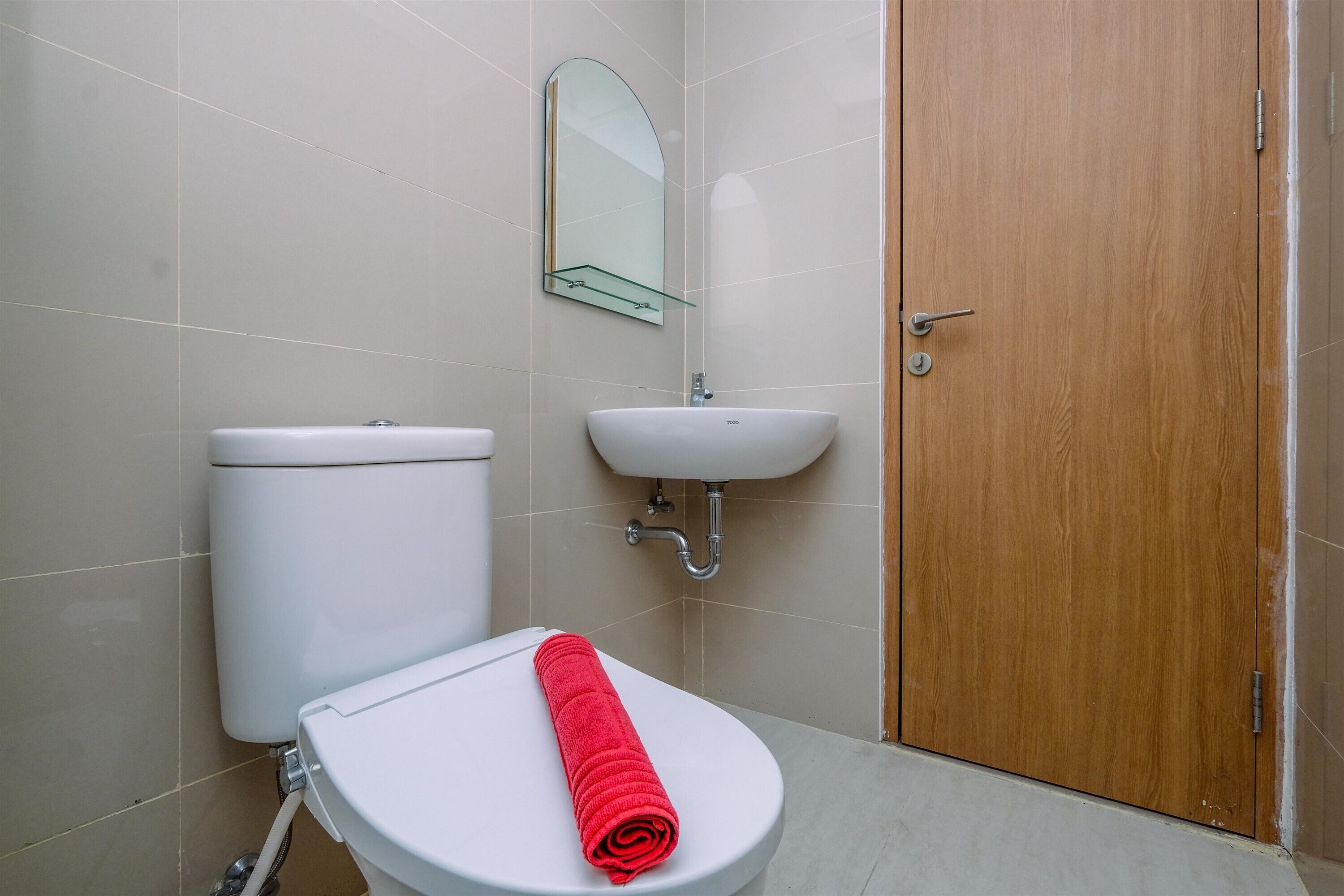 Une salle de bain avec des toilettes, un lavabo et une porte en bois.
