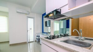 A modern kitchen with a granite countertop, stainless steel sink, and a built-in stove. - Elegant Studio Apartment At B Residence Near Aeon Mall (Pagedangan)
