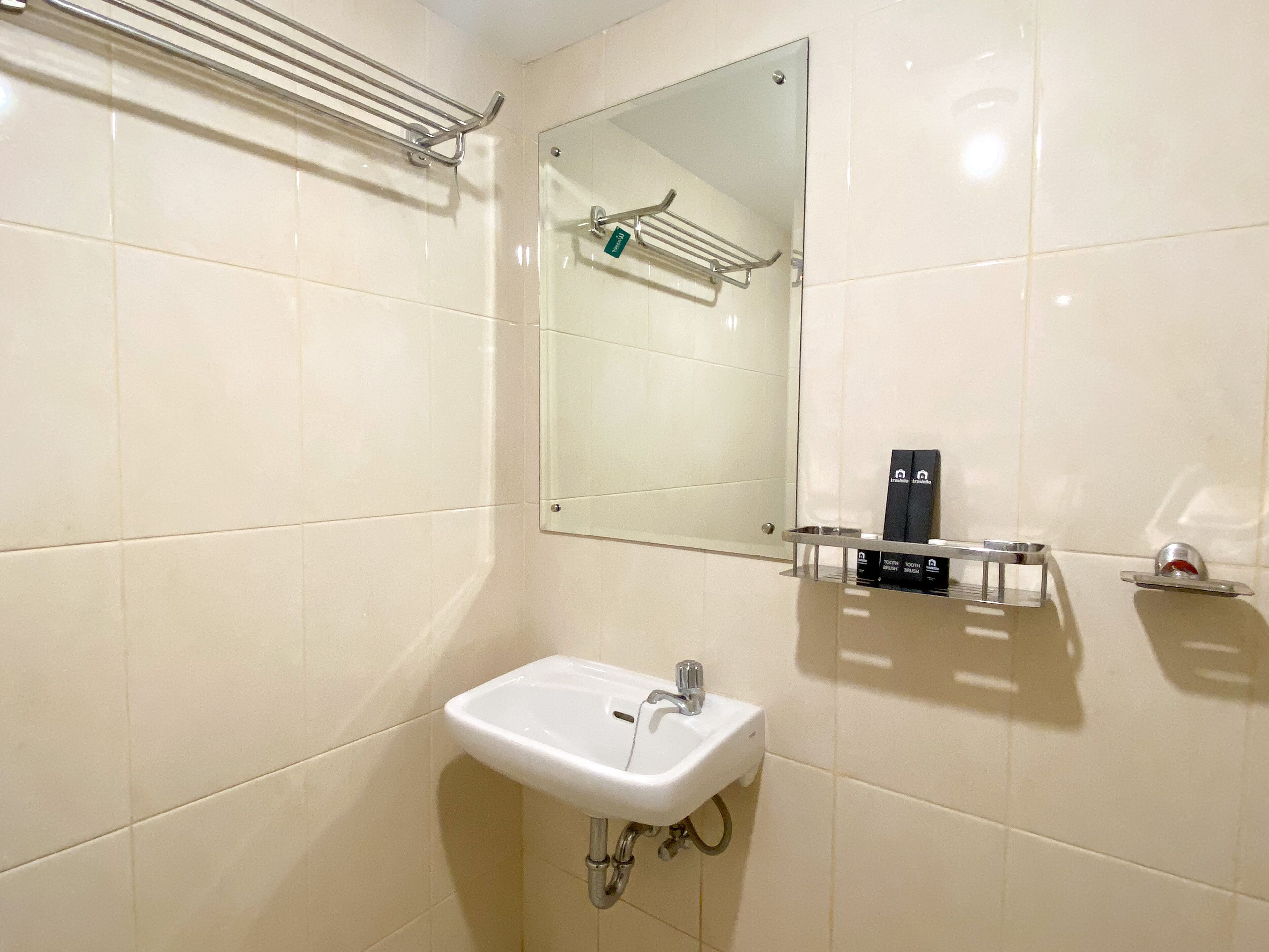 A bathroom with a white sink, a mirror, and a towel rack.