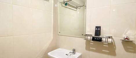 A bathroom with a white sink, a mirror, and a towel rack.