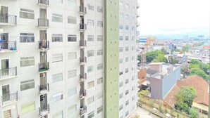 A high-rise building with multiple balconies and large windows. - Nice Studio Room At Grand Asia Afrika Apartment (Bandung)