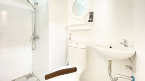A modern bathroom with a shower, toilet, and sink. - Nice Studio Room At Grand Asia Afrika Apartment (Bandung)