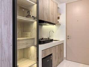 A modern kitchen with wooden cabinets, a built-in stove, and a dishwasher.