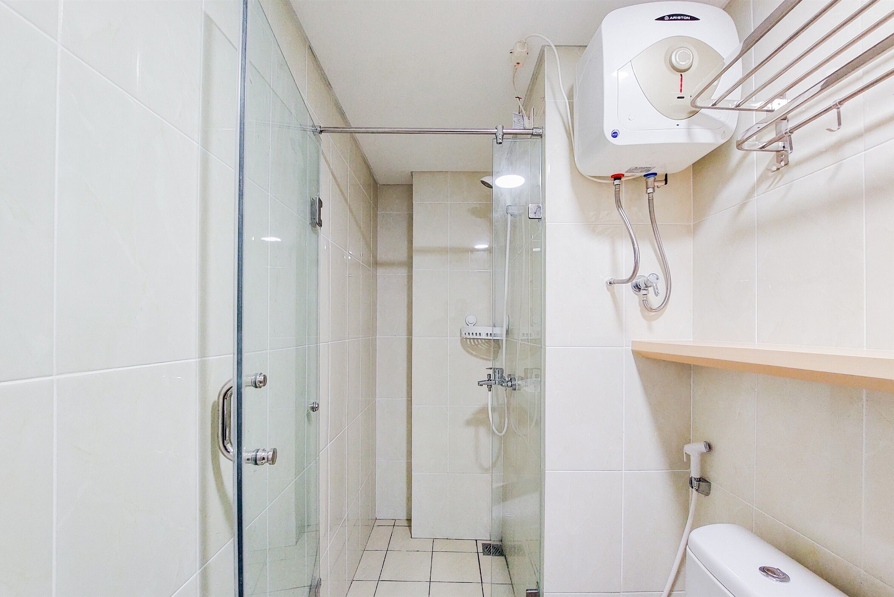 Une salle de bain moderne dotée d’une douche à parois de verre, de toilettes et d’un sèche-mains.