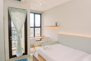 Une chambre à coucher comprenant un lit, un bureau, une chaise, une fenêtre avec un rideau et une petite étagère sur laquelle est posée une plante.