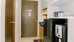 A compact kitchen with a refrigerator, a coffee maker, and a microwave. - Good Deal And Simply Look Studio Room At Transpark Bintaro Apartment (South Tangerang)