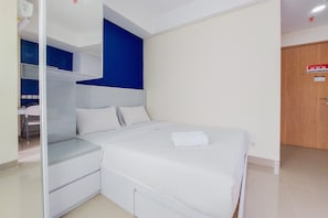 A bedroom with a bed, a wardrobe, and a desk. - Simply Look And Warm Studio Apartment At B Residence (Pagedangan)