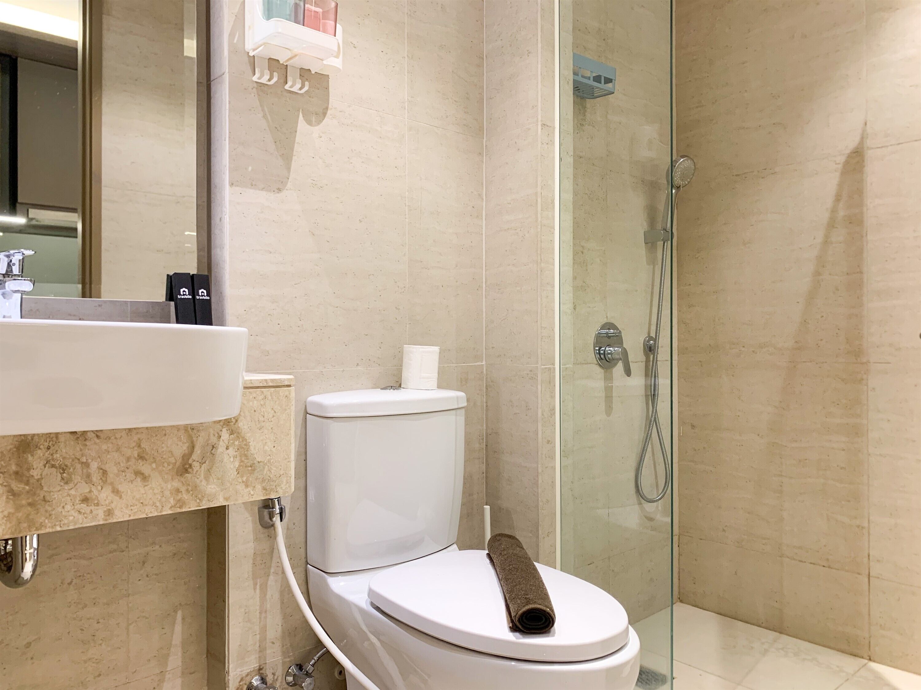 A bathroom with a toilet, sink, and glass-enclosed shower.