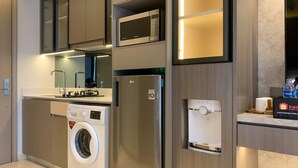 A modern kitchen with built-in appliances including a washing machine, a microwave, and a refrigerator.