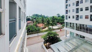 A multi-story building with balconies and a glass facade. - Enjoy Living And Warm Studio At Serpong Garden Apartment (Cisauk)