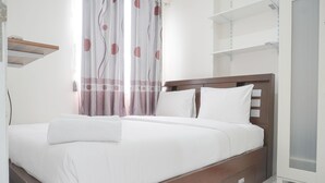 Ein ordentlich bezogenes Bett mit weißen Leinen, ein hölzernes Kopfteil und ein Nachttisch mit einer Lampe.