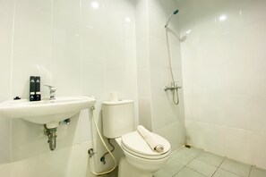 A bathroom with a white sink, toilet, and shower. - Comfort 1Br At Patraland Urbano Apartment (Bekasi)