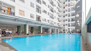 An indoor swimming pool with a clear view of the surrounding building's exterior. - Chic And Cozy 2Br At Mekarwangi Square Cibaduyut Apartment (Bandung)