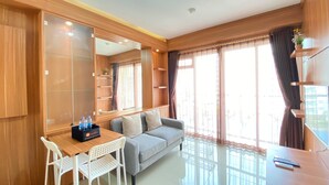 Ein modernes Zimmer mit einer Couch, einem Esstisch und einem Spiegel.