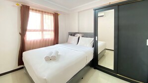 Ein Hotelzimmer mit Bett, Schrank und einem Vorhangfenster.