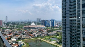 A high-rise building with a view of a cityscape, including a mix of residential and commercial buildings. - Comfort And Enjoy Living 2Br At Daan Mogot City Apartment (Jakarta)