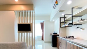 Una cocina moderna con estufa integrada, televisor de pantalla plana en la pared y comedor con mesa y sillas de madera.