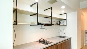 Una cocina moderna con encimera de granito, armarios de madera, estufa integrada e iluminación debajo de los armarios.