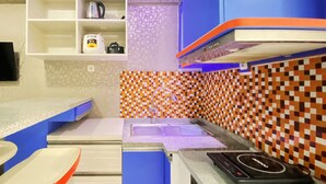 A kitchen with a modern design, featuring a microwave, a sink, and a stove. - Graceful 2Br Apartment At Gateway Ahmad Yani Cicadas (Bandung)