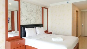 A hotel room with a large bed, wooden nightstands, a marble-patterned wall, and a door.