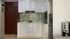 Una cucina moderna con mobili bianchi, zoccolo paraschizzi decorato e piano cottura integrato.