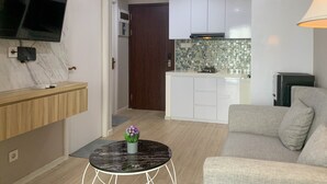Un soggiorno moderno con un divano, un tavolino da caffè e una TV a parete.