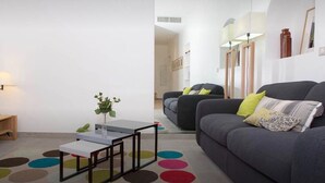 A modern living room with a grey sofa, a small white table, and a colorful rug. - La Croisette - One Bedroom Apartment, Sleeps 4 (Cannes)