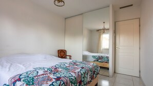 A bedroom with a bed, a chair, a wardrobe, and a door. - La Massane - Three Bedroom House, Sleeps 6 (Argeles-sur-Mer)