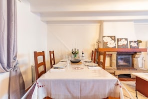 Een eetgedeelte met een tafel voor vier personen, een open haard en een decoratieve wand.